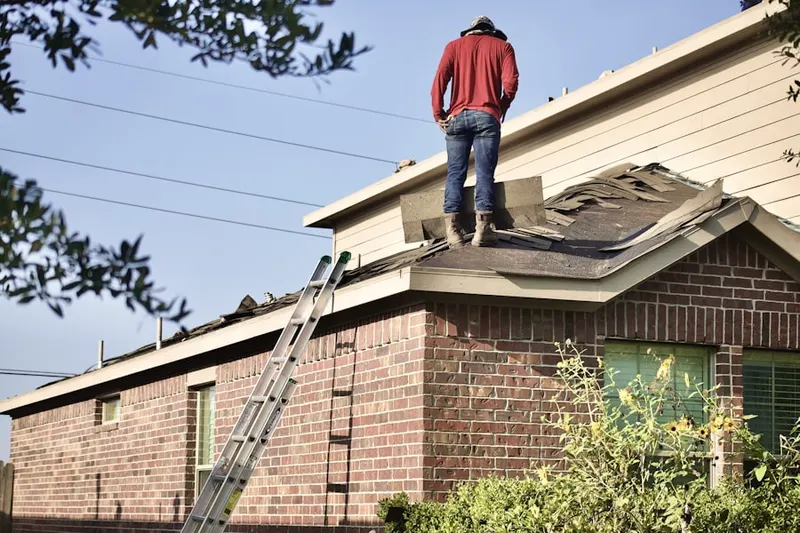 Professional roofer working on a residential roof in Garfield
